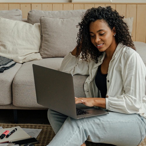 a woman sitting on the floor with a computer